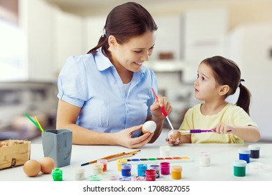 Happy mother and daughter painting Easter egg in the kitchen - Shutterstock ID 1708827055