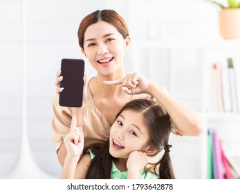 Happy Mother And Daughter Showing The Mobile Phone