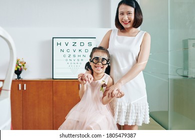 Happy Mother And Daughter In Trial Frames In Office Of Pediatric Ophthalmologist