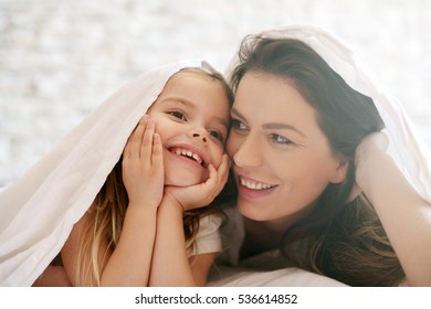 Happy Mother And Daughter Under Blanket. 
