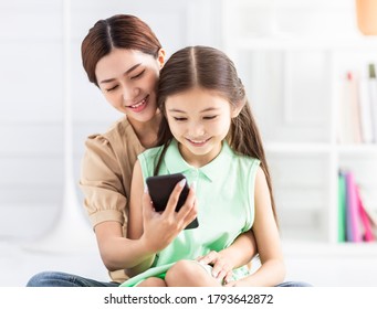 Happy Mother And Daughter Watching The Smart Phone