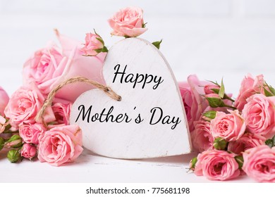 Happy Mother Day background. Pink roses flowers and decorative  white  heart. Selective focus. 