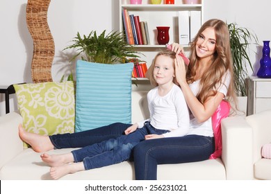 Happy mother doing daughter's hairdo - Powered by Shutterstock