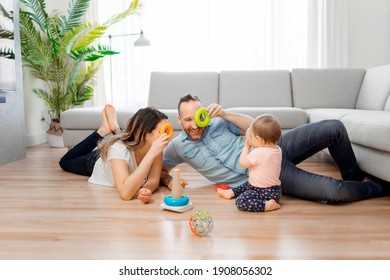 Eine glückliche Mutter und Vater mit einer kleinen Tochter, die zu Hause spielt