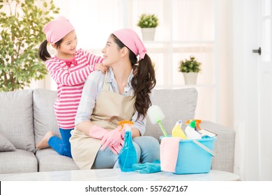 happy mother feel daughter very filial piety helping her massage and house cleaning looking each other in living room at home. housework and household concept.