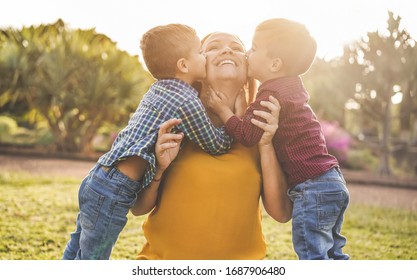 Happy mother having fun with her two sons playing outdoor - Love and family concept - Focus on mother face