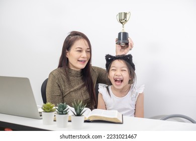 Happy mother helping daughter learning online virtual class on laptop together at home. - Shutterstock ID 2231021467