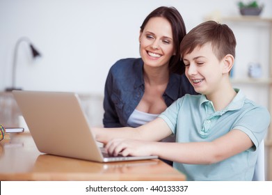 Happy mother helping his son to do homework