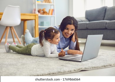 Happy Mother And Her Cute Little Daughter Watching Online Entertainment Video Together On Laptop At Home