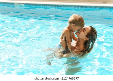 Happy mother and her cute little son swimming in outdoor pool during summer vacation - Powered by Shutterstock