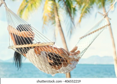 Happy Mother With Her Daughter Lying In A Hammock On The Shore Of A Tropical Beach. Mothers Day. 