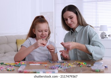 Happy Mother With Her Daughter Making Beaded Jewelry At Home