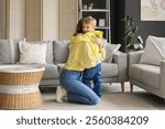 Happy mother and her little son hugging on floor in living room at home