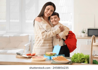 Happy mother with her little son hugging before school in kitchen - Powered by Shutterstock