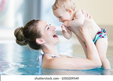 Happy mother and her newborn child at infant swimming class
