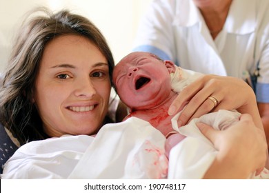 Happy Mother Holding Her Baby, Seconds After She Gave A Birth, Natural Child Birth