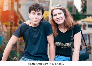 Happy mother hug her teenage son and rejoices because she is reconciled with her son with whom she had a complicated relationship. The son and mother spend their time together