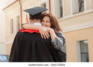 Happy Mother hugs her son student in graduation gown and a square cap after the graduation ceremony - Powered by Shutterstock