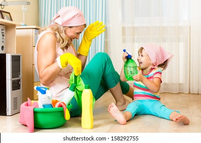 Happy Mother With Kid Cleaning Room And Having Fun