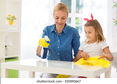 Happy Mother With Kid Cleaning Room And Having Fun At Home