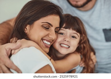 Happy mother, kid and hug family for care, support and connection in home. Mom, smile and girl child embrace parents for adoption, love and bonding together for trust with hand of father in lounge - Powered by Shutterstock