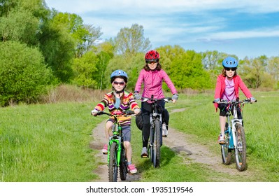 Happy Mother And Kids On Bikes Cycling Outdoors In Park, Active Family Sport  And Fitness Together
