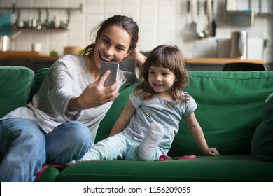 Happy Mother Laughing Taking Selfie With Child Daughter On Smartphone At Home, Smiling Single Mom And Cute Girl Playing Making Photo Posing For Self Portrait, Mommy And Kid Shooting Stories