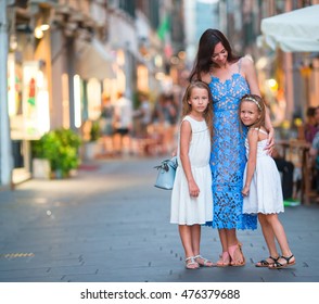 Happy Mother And Little Adorable Girls On Cozy Street During Italian Vacation. Family European Vacation.