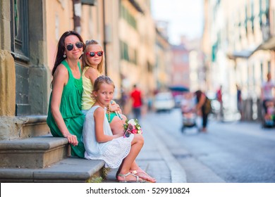 Happy Mother And Little Adorable Girls On Cozy Street During Italian Vacation. Family European Vacation.