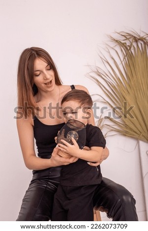 A happy mother with a little boy , in black clothes