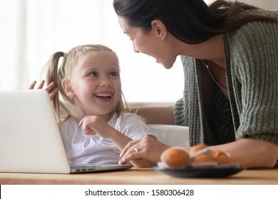 Happy Mother And Little Daughter Having Fun With Laptop Close Up, Laughing At Funny News, Playing Video Game Or Watching Cartoons, Shopping Online, Smiling Mum Teaching Adorable Child To Use Computer