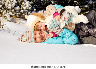 Happy mother and little girl lying in snow - Powered by Shutterstock