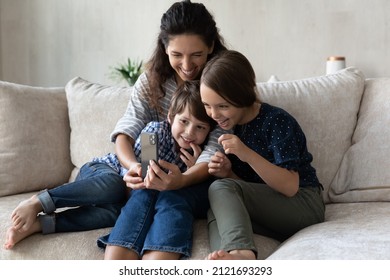 Happy Mother With Little Son And Daughter Taking Selfie, Having Fun With Smartphone Together, Smiling Loving Mom And Kids Looking At Phone Screen, Making Video Call Or Watching Funny Cartoons