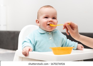 Happy Mother Nanny Or Sister Feeds A Little Baby With A Spoonful Of Food At Home - Shutterstock ID 1670276926