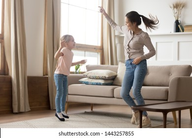 Happy Mother And Preschool Daughter Jumping, Having Fun At Home, Older Sister With Preschool Girl Dancing To Favorite Song, Enjoying Music, Funny Activity, Enjoying Family Weekend Together