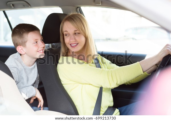 Happy mother and son driving in city during\
sightseeing tour