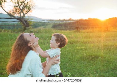 Happy mother and son on nature on sunset. Family, children and happy people concept. Mothers day