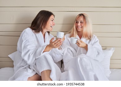 Happy mother and teenage daughter drinking coffee and talking - Powered by Shutterstock