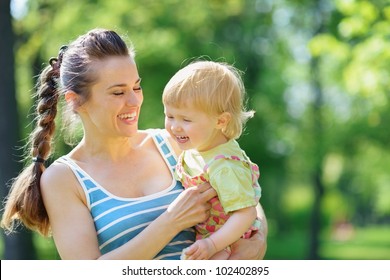 Happy Mother Tickling Baby Outside