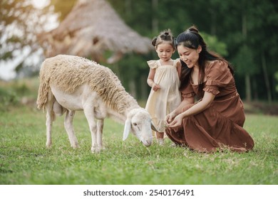 happy mother with toddler baby girl resting with sheep on a field - Powered by Shutterstock