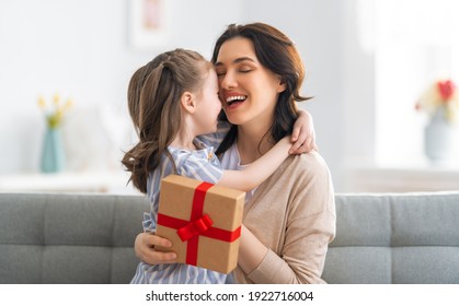 Happy Mother's Day! Child Congratulating Mom. Mum And Daughter Smiling And Holding Gift. Family Holiday And Togetherness.