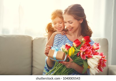 Happy Mother's Day! Child Daughter Congratulates Mother And Gives A Bouquet Of Flowers To Tulips And Gift
