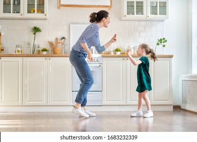 Happy mother's day! Child daughter and mom cooking and having fun in the kitchen at home. Family holiday and togetherness.                               
