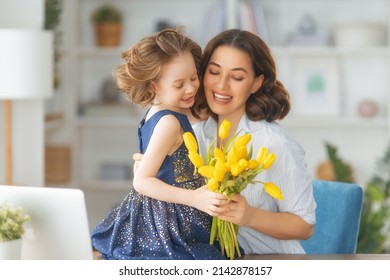 Happy mother's day. Child daughter congratulating mom and giving her flowers. Mum and girl smiling and hugging. Family holiday and togetherness. - Powered by Shutterstock