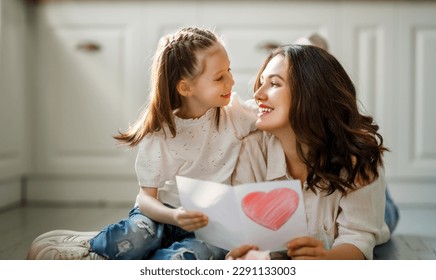 Happy mother's day. Child daughter congratulating her mother and giving her postcard. - Powered by Shutterstock