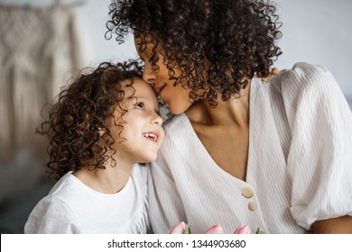 Happy mother's day, daughter gives a bouquet of tulips. African-American girl with a smile without teeth - Powered by Shutterstock