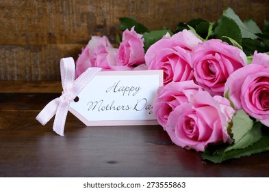 Happy Mothers Day Fresh Pink Roses On Dark Wood Distressed Table And Background, With Gift Tag.  