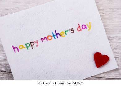 Happy Mother`s Day greeting card. Fabric heart near inscription. Make colorful congratulation. Prepare a nice surprise.