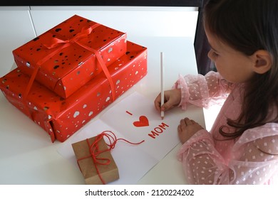 Happy Mother's Day! A little girl makes a postcard and gifts for mom.
