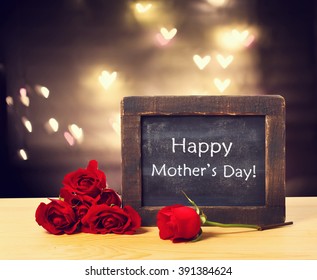 Happy Mothers Day Message On A Small Chalkboard With Red Roses
